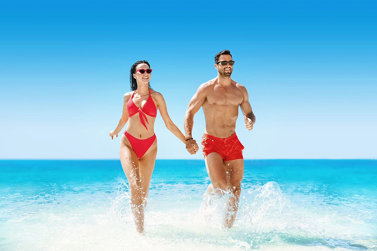 Joyful man and woman run by the sea