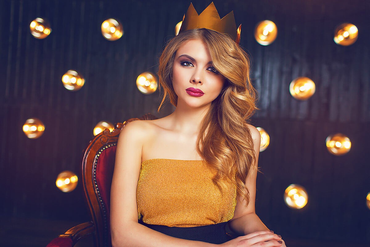 Business woman sitting on a chair with a crown on her head