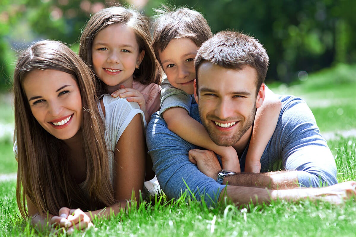 Joyful couple playing with children outdoors
