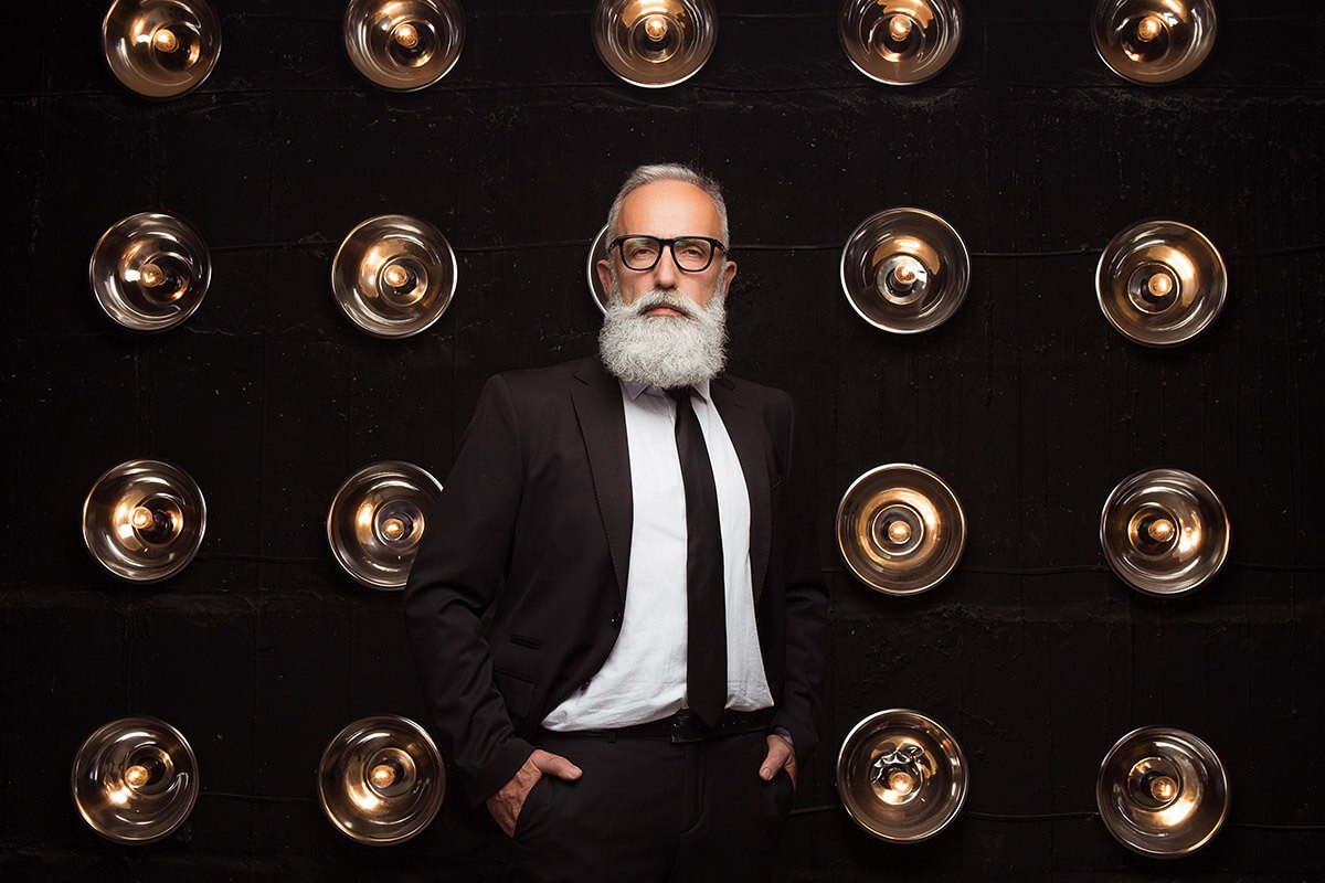 Brutal man stands on a background of light bulbs