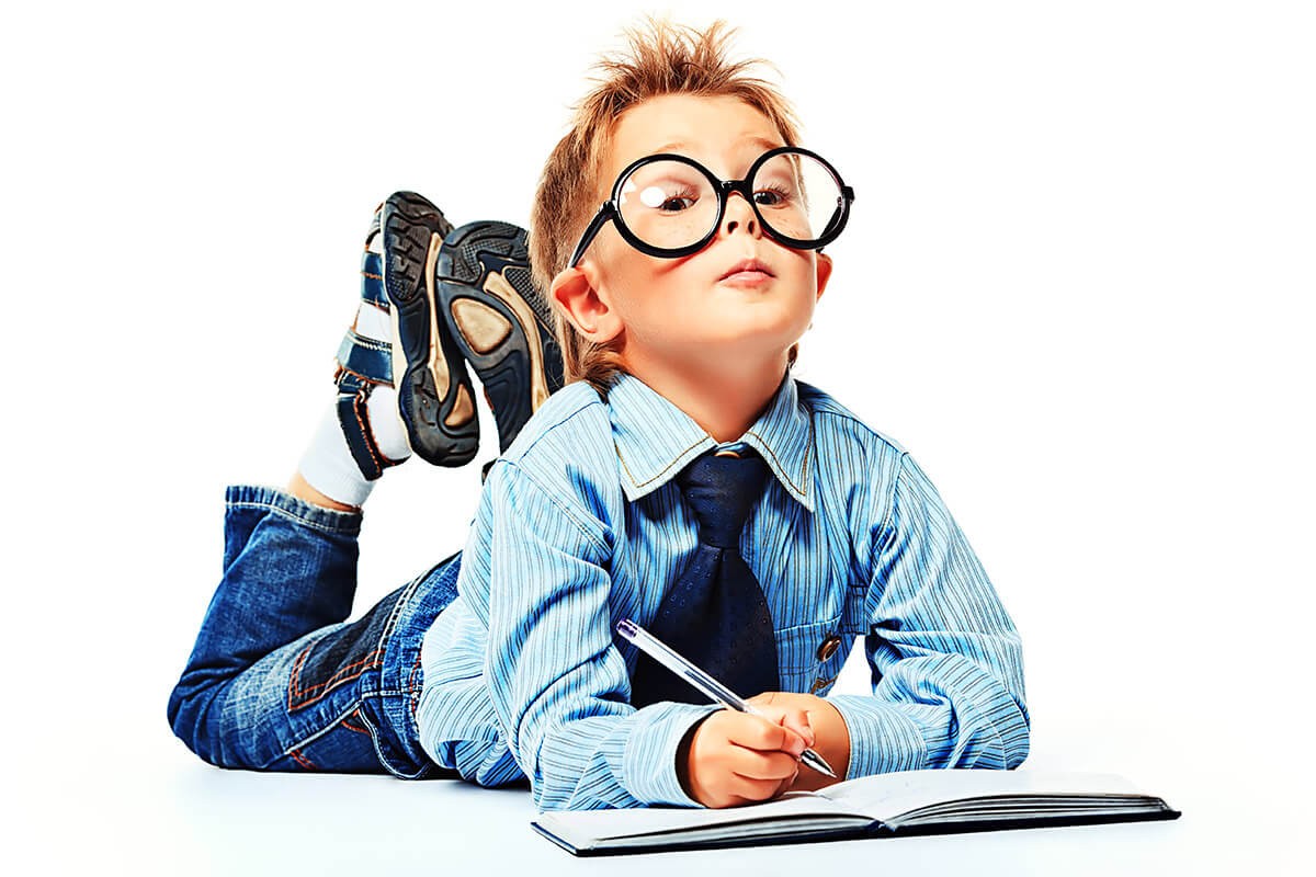 Smart child in glasses with a notebook and pen
