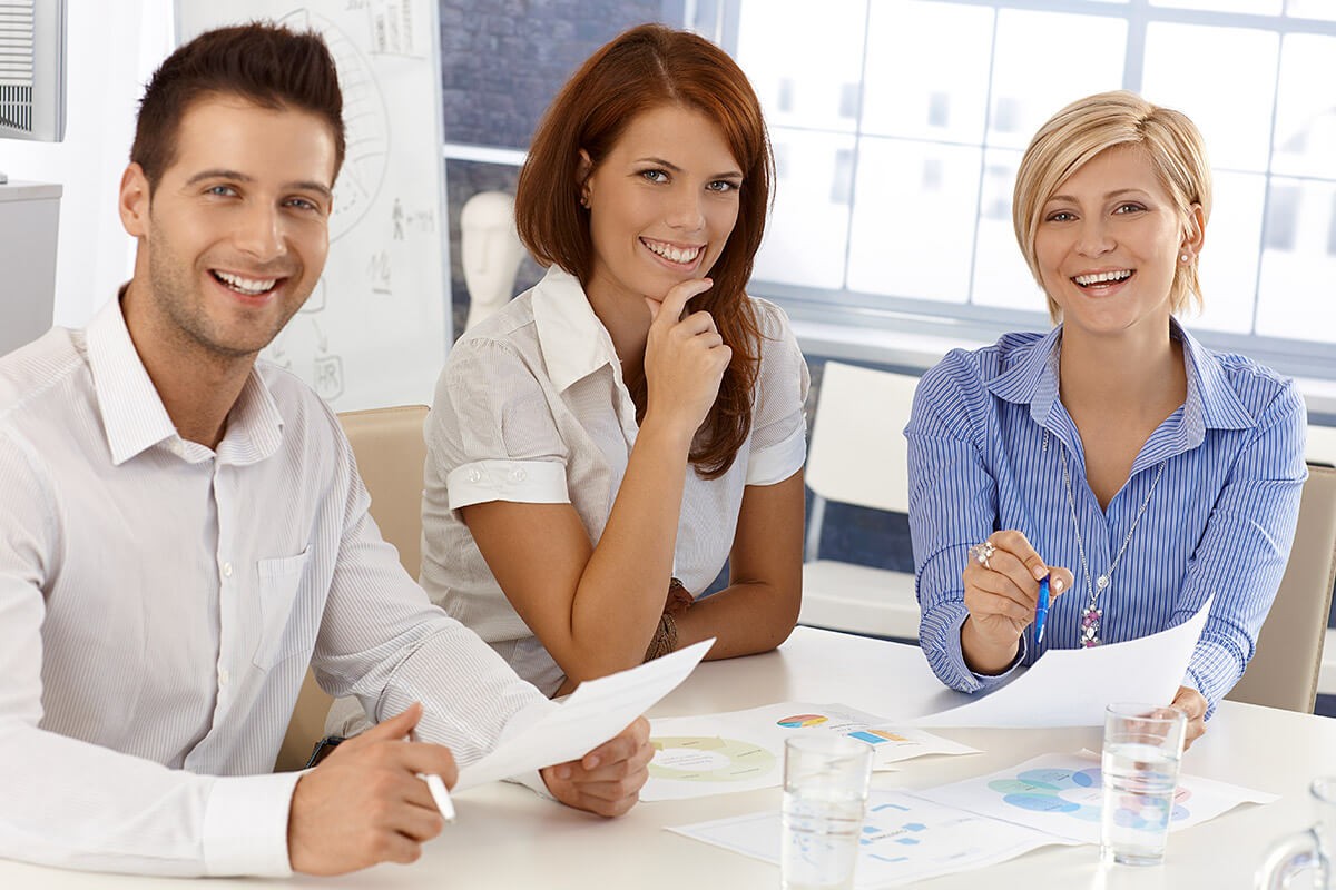 A company of young people sits at a desk