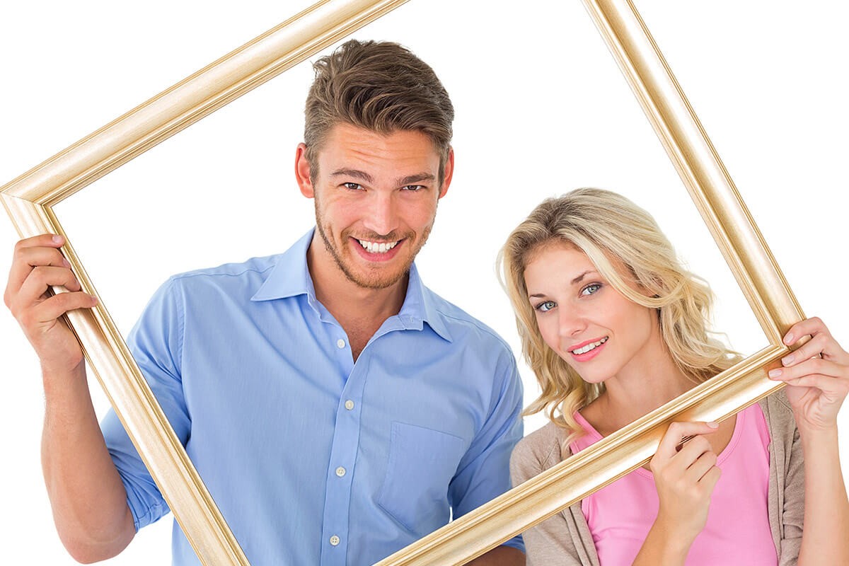 Loving couple looks through the frame from the picture