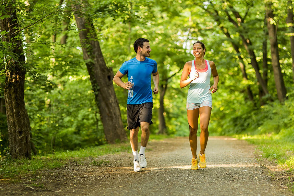 Man and woman run through the forest