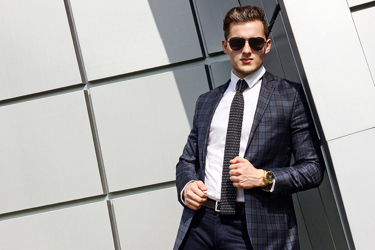 Successful man stands in a business suit and glasses