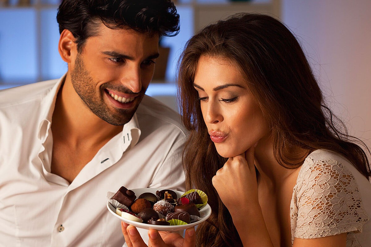 The husband offers his wife to eat chocolates
