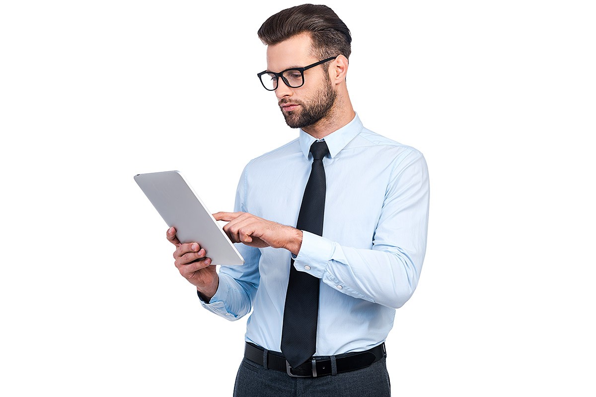 Purposeful young man looks at the tablet