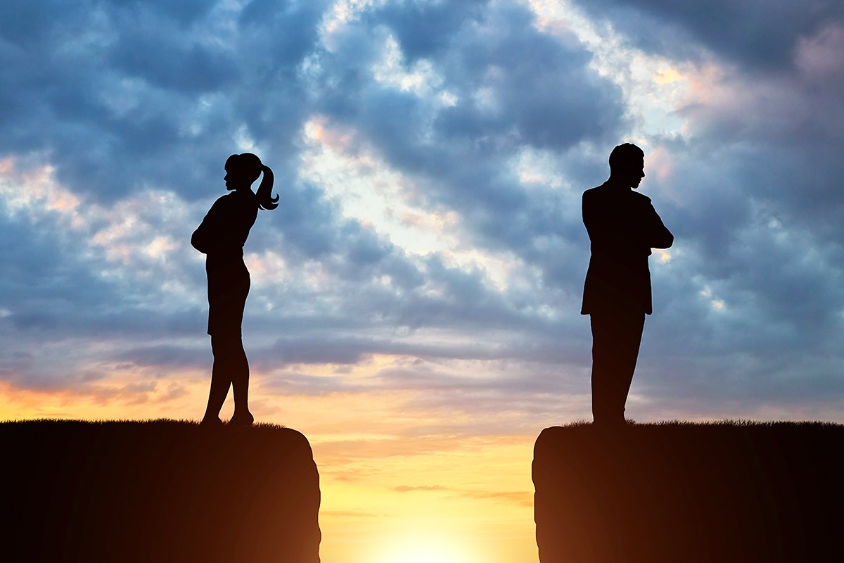 Image of man and woman standing on different sides of the cliff