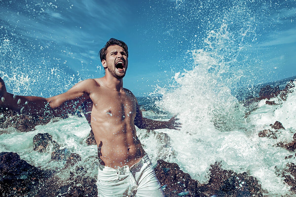 Man emotional screams and goes from strong waves splashing