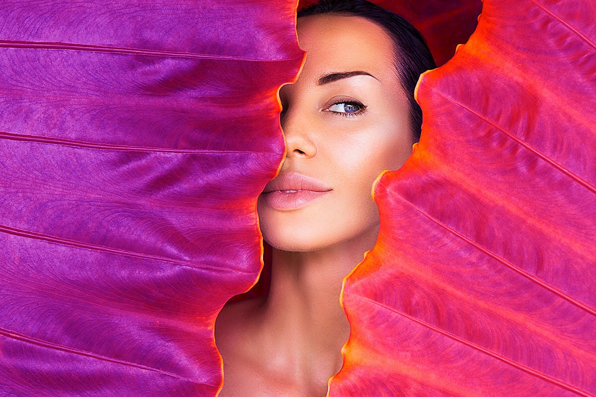 Image of a woman peeking through the leaves