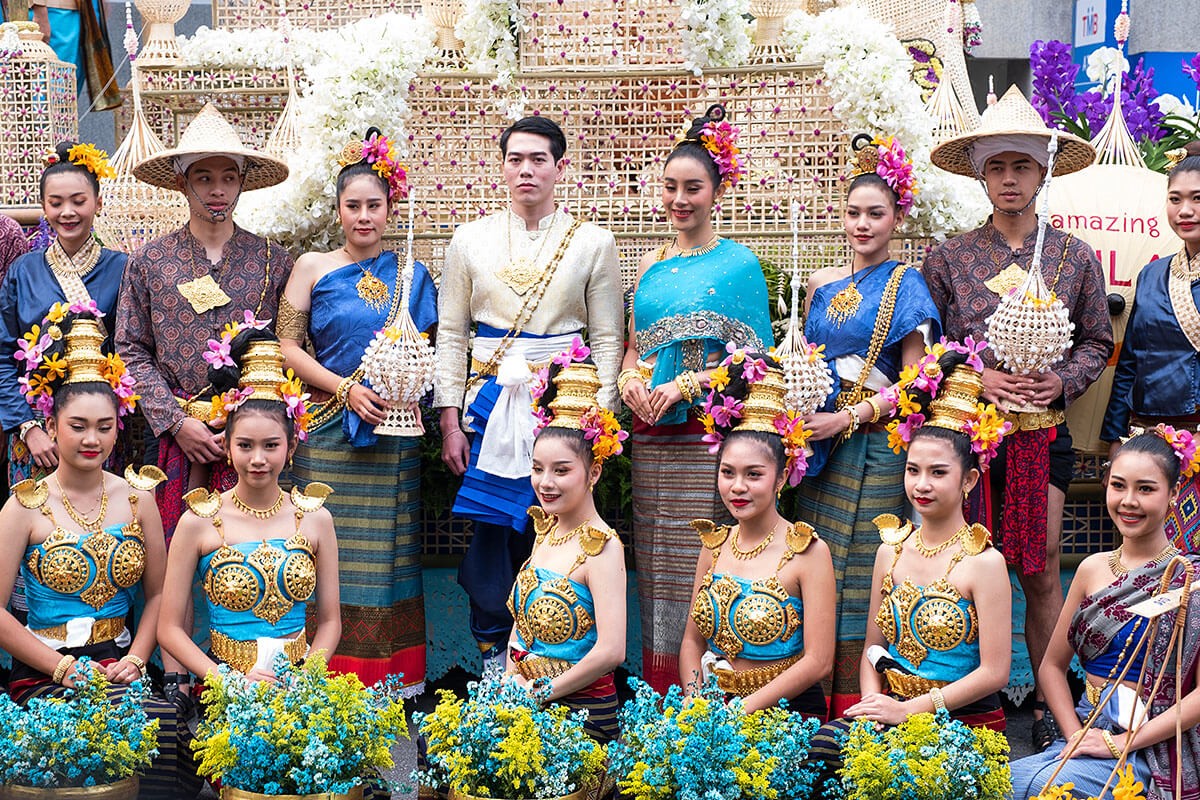 Image of men and women with flowers in their hands and traditional costumes - Flower Festival Parade, Chiang Mai, Thailand