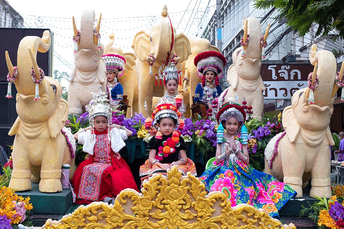 Image of women and children sitting in a flower float - Annual Flower Festival Parade, Thailand