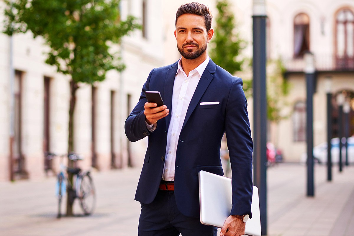Image of a business man with a phone and laptop