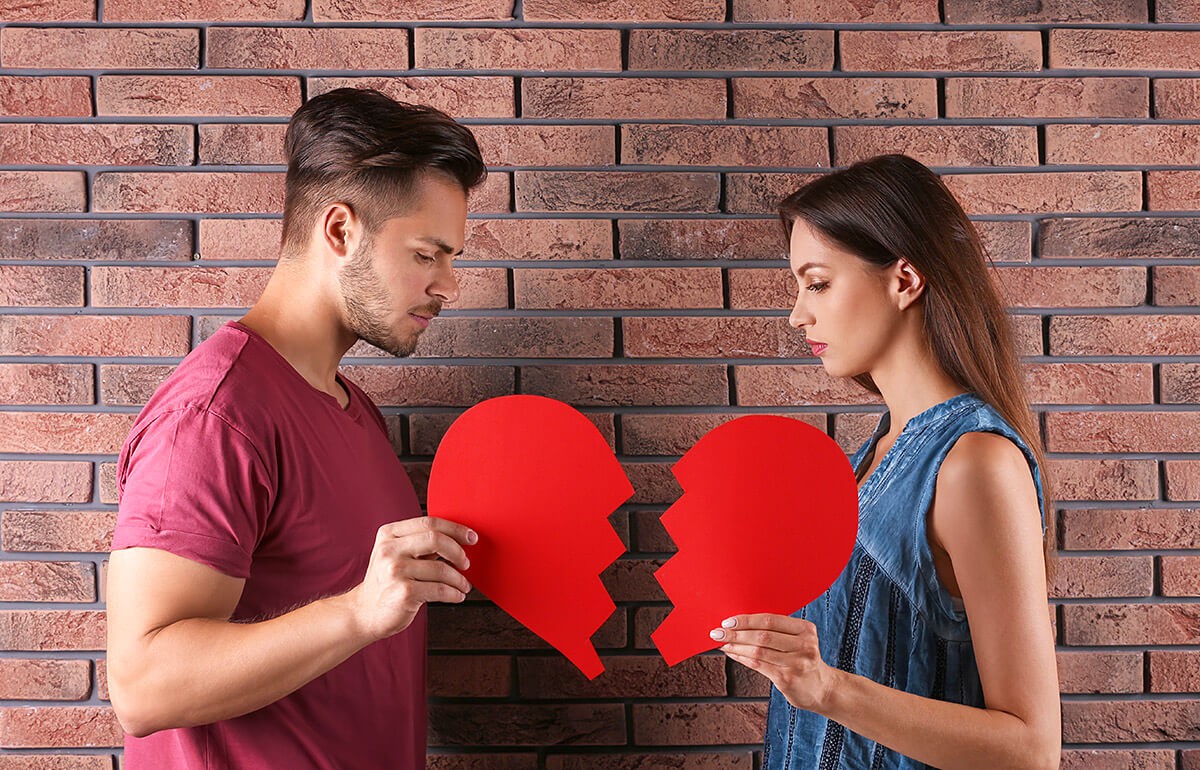 Image of man and woman with halves of paper heart in hands