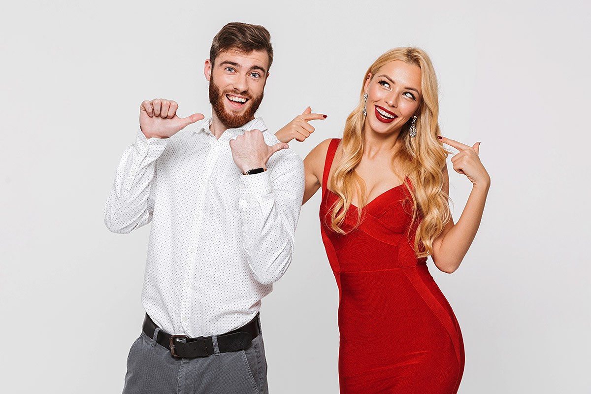 Image of a man pointing his hands at an attractive girl in a red dress