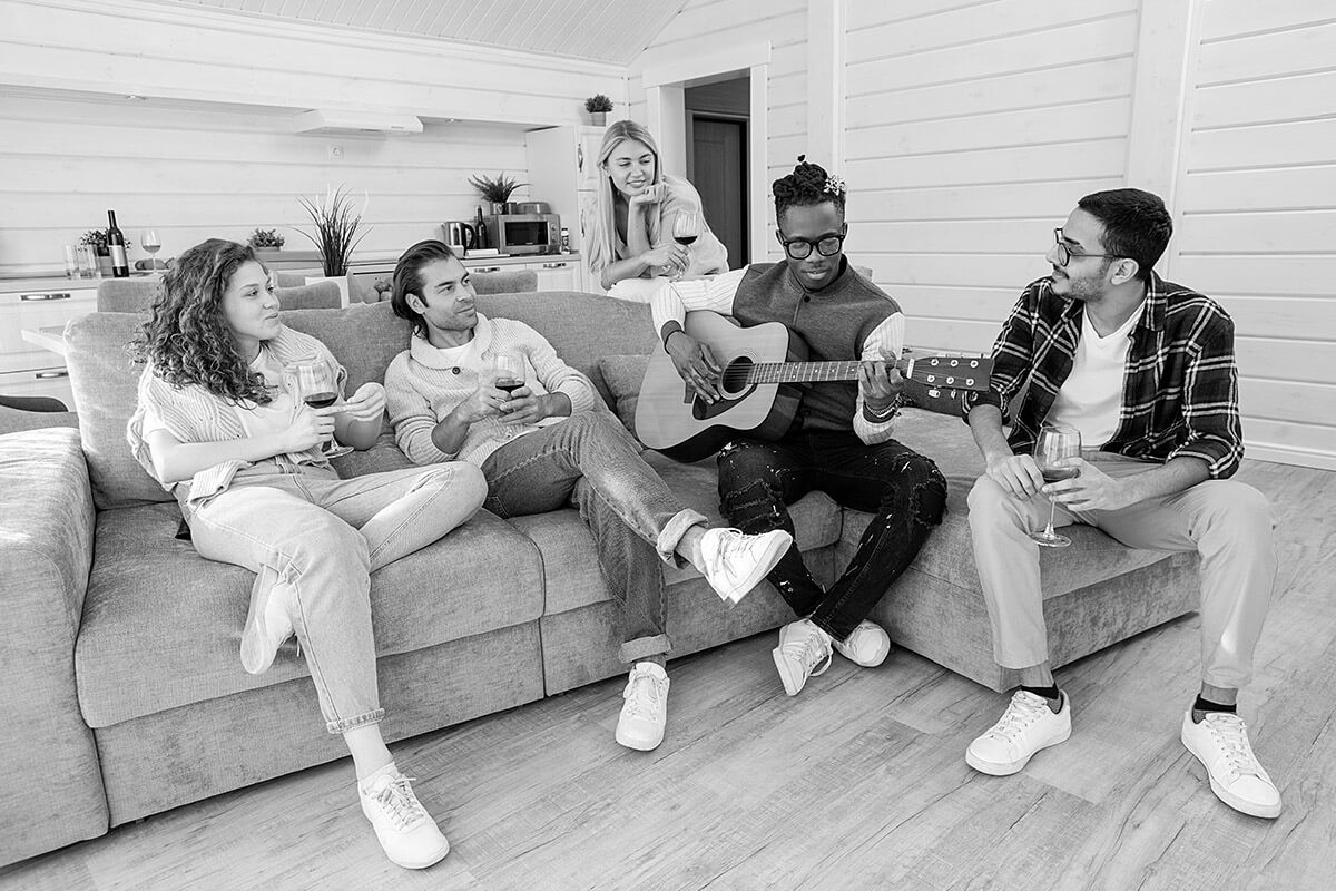 Young man playing guitar in the company of their friends
