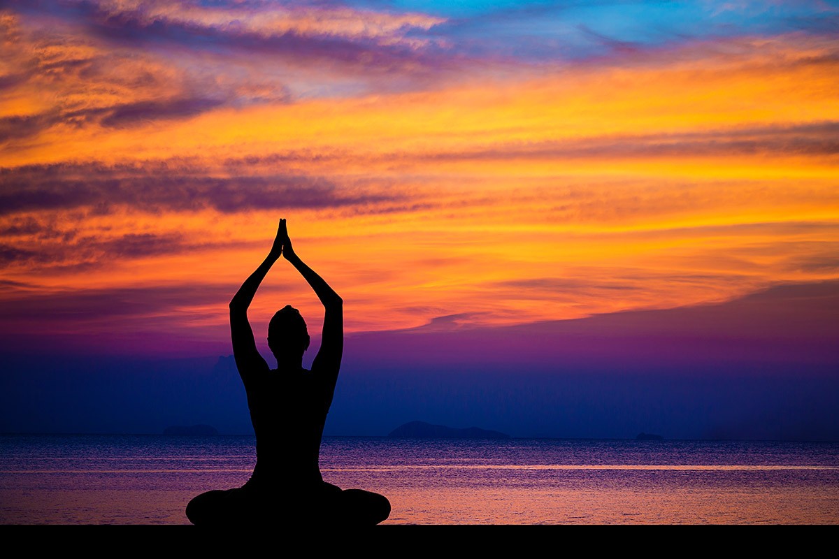 Woman relaxes by the sea at sunset