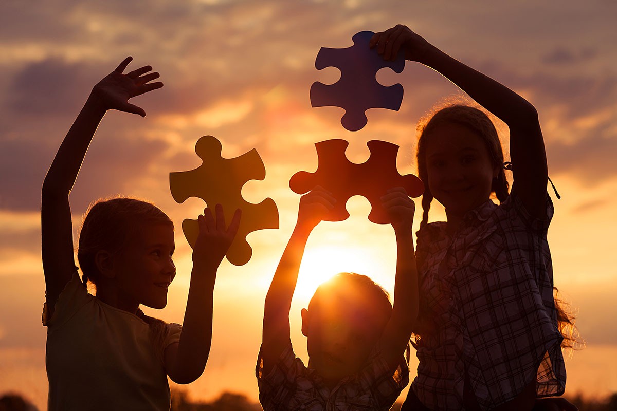 Children at sunset collect puzzles