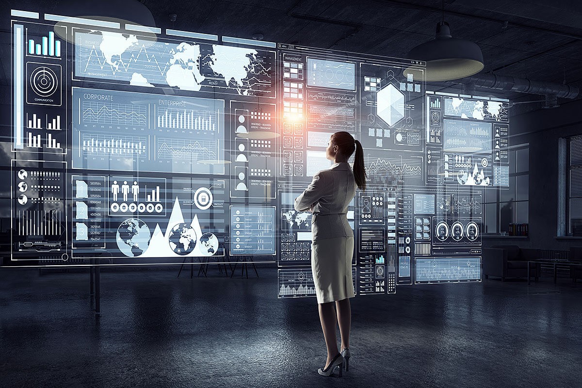 A woman looks at a large screen with graphs of economic development