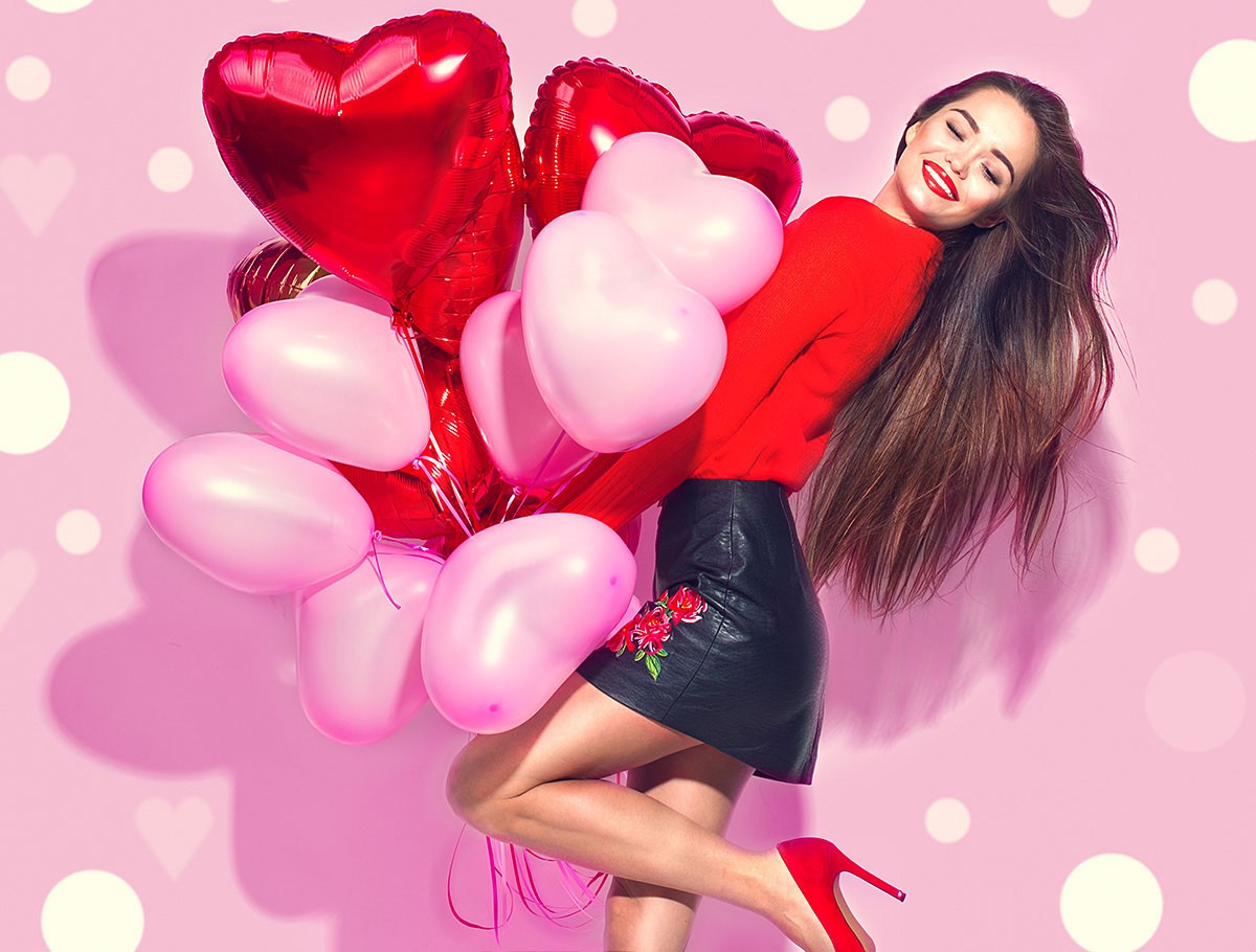 Beautiful girl with balloons in the form of hearts