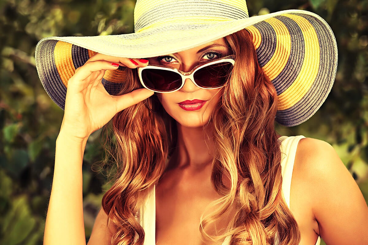 Beautiful woman in a big hat and sunglasses