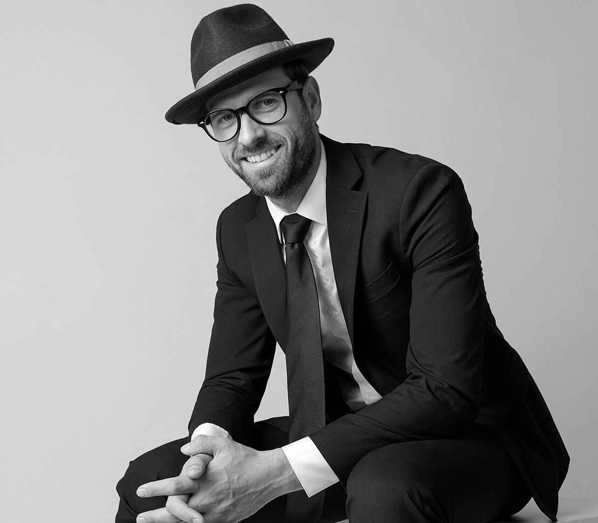 Jealous man in a business suit, hat and glasses
