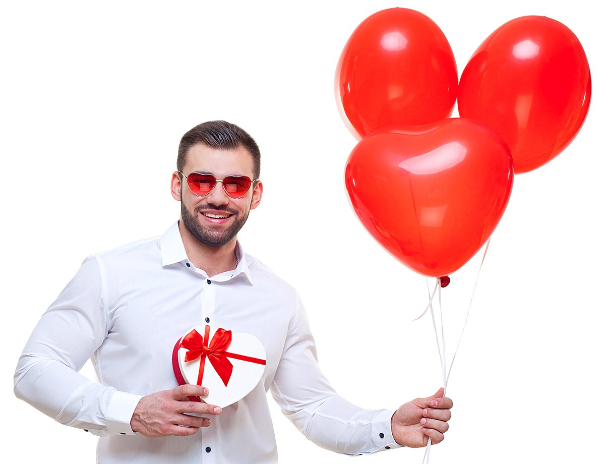 Young man with a box of chocolates and red balloons