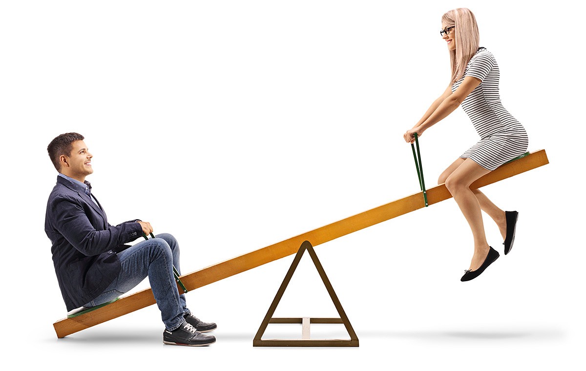 A young couple is riding on a swing and the man outweighs