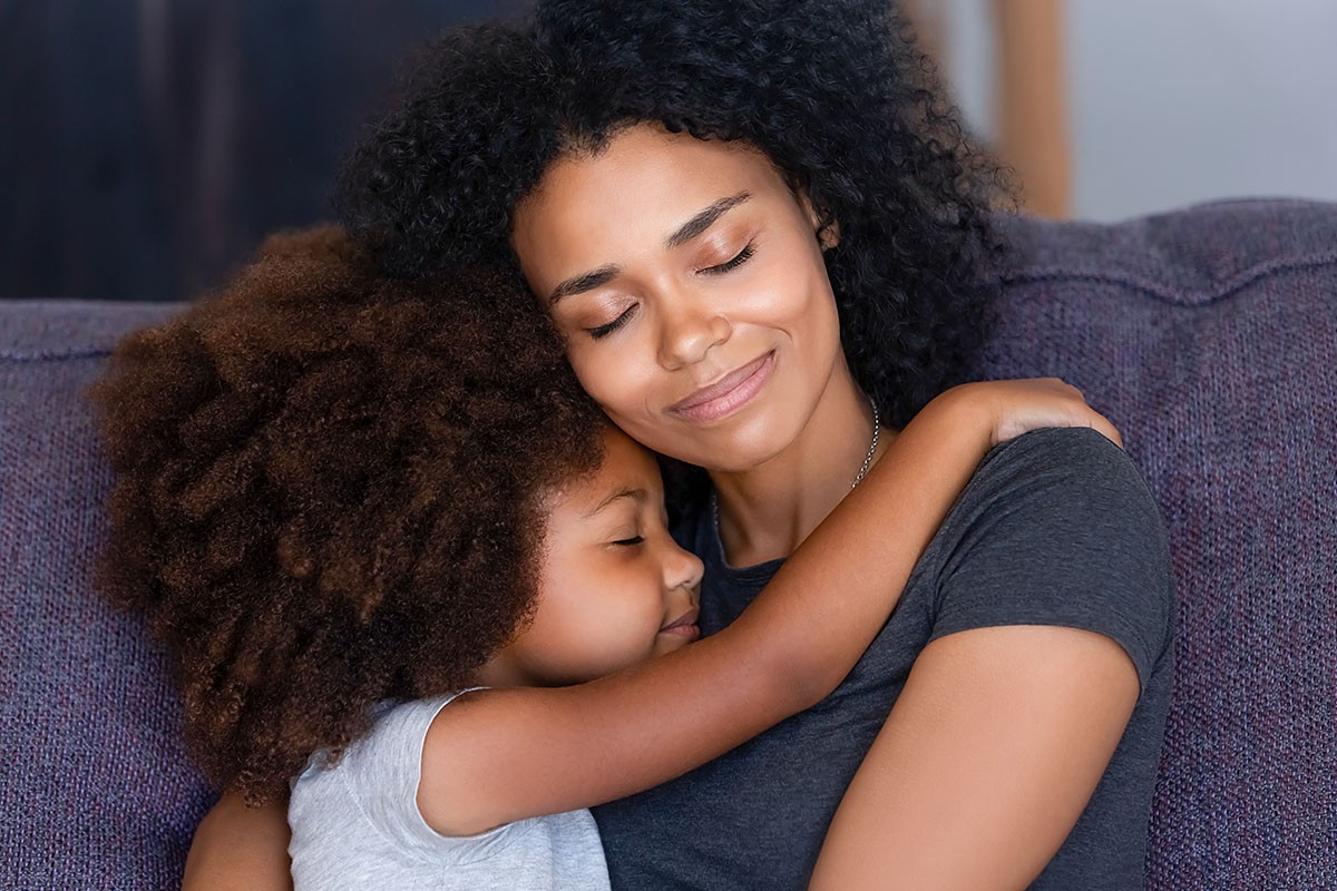 Image of mom tenderly hugging her sleeping child