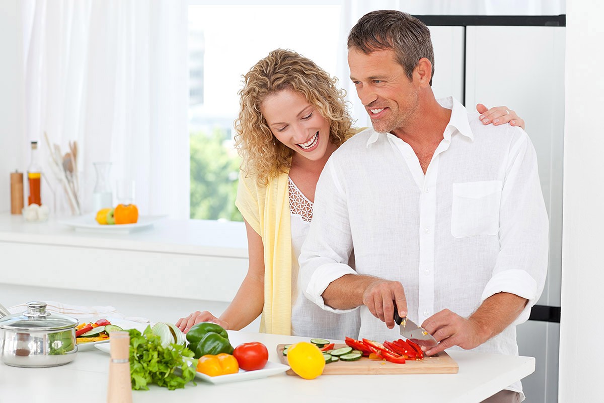 Man preparing food in the kitchen with his wife