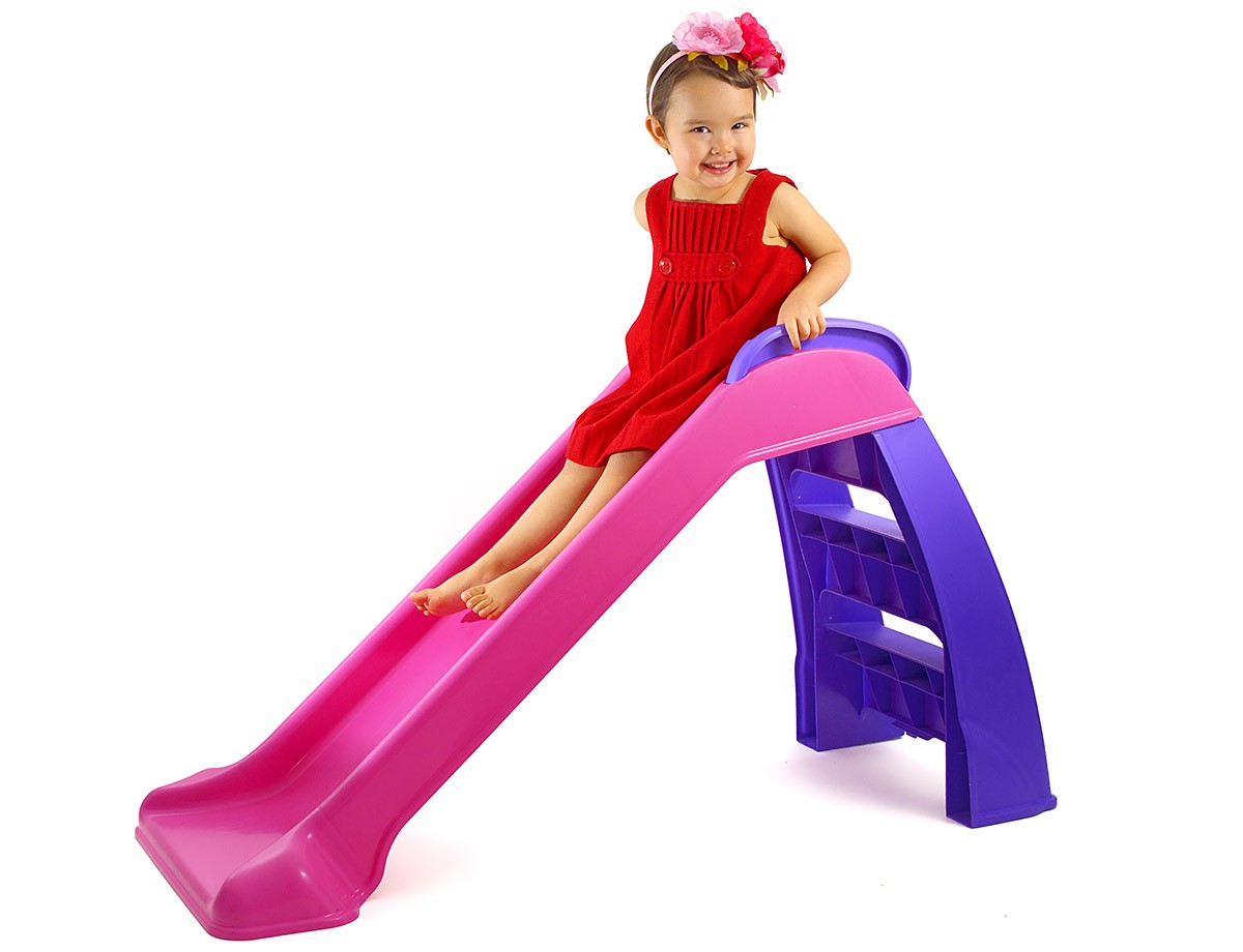 A little girl riding down a children's slide