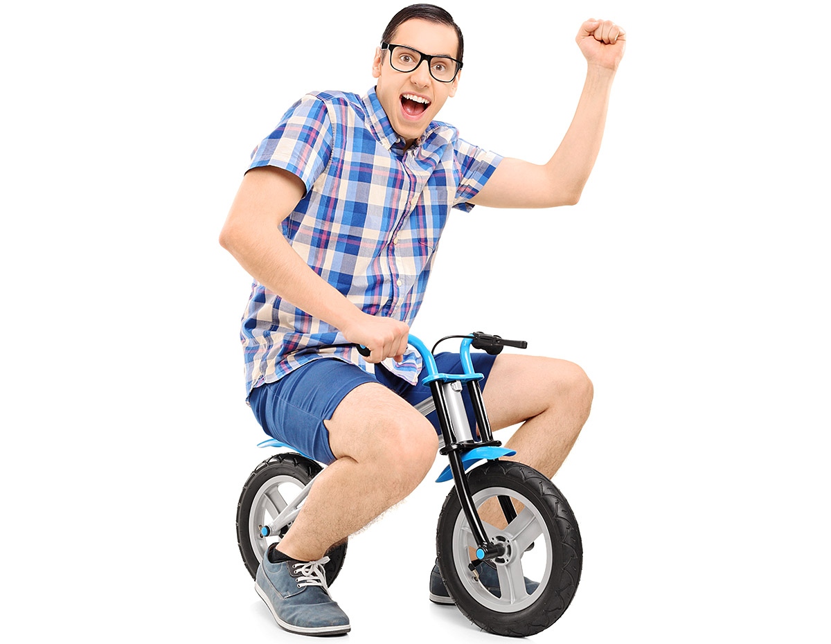 Cheerful adult man rides a child's little bike