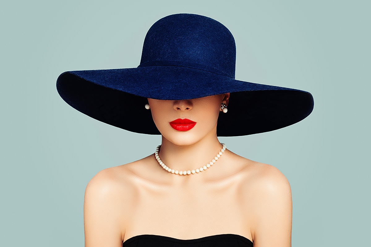 Pretty woman with red lipstick and a big hat