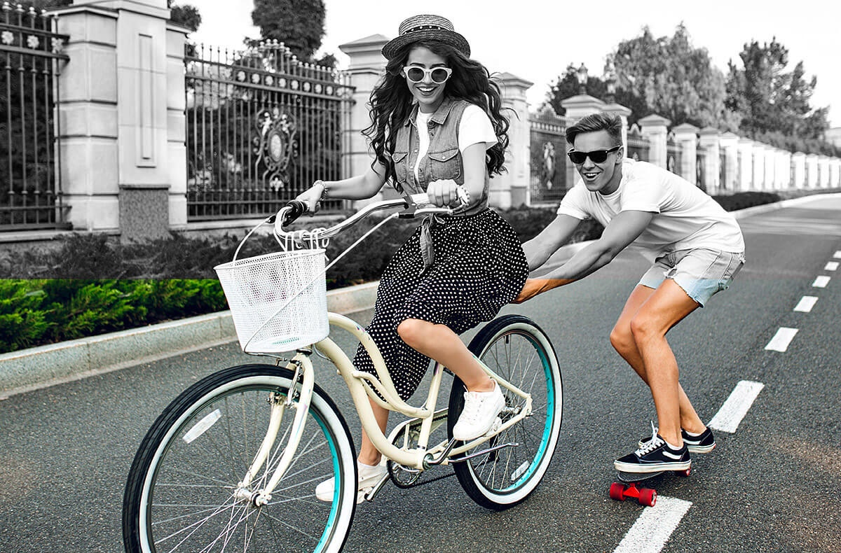 Image of a girl on a bicycle and a guy on a skateboard