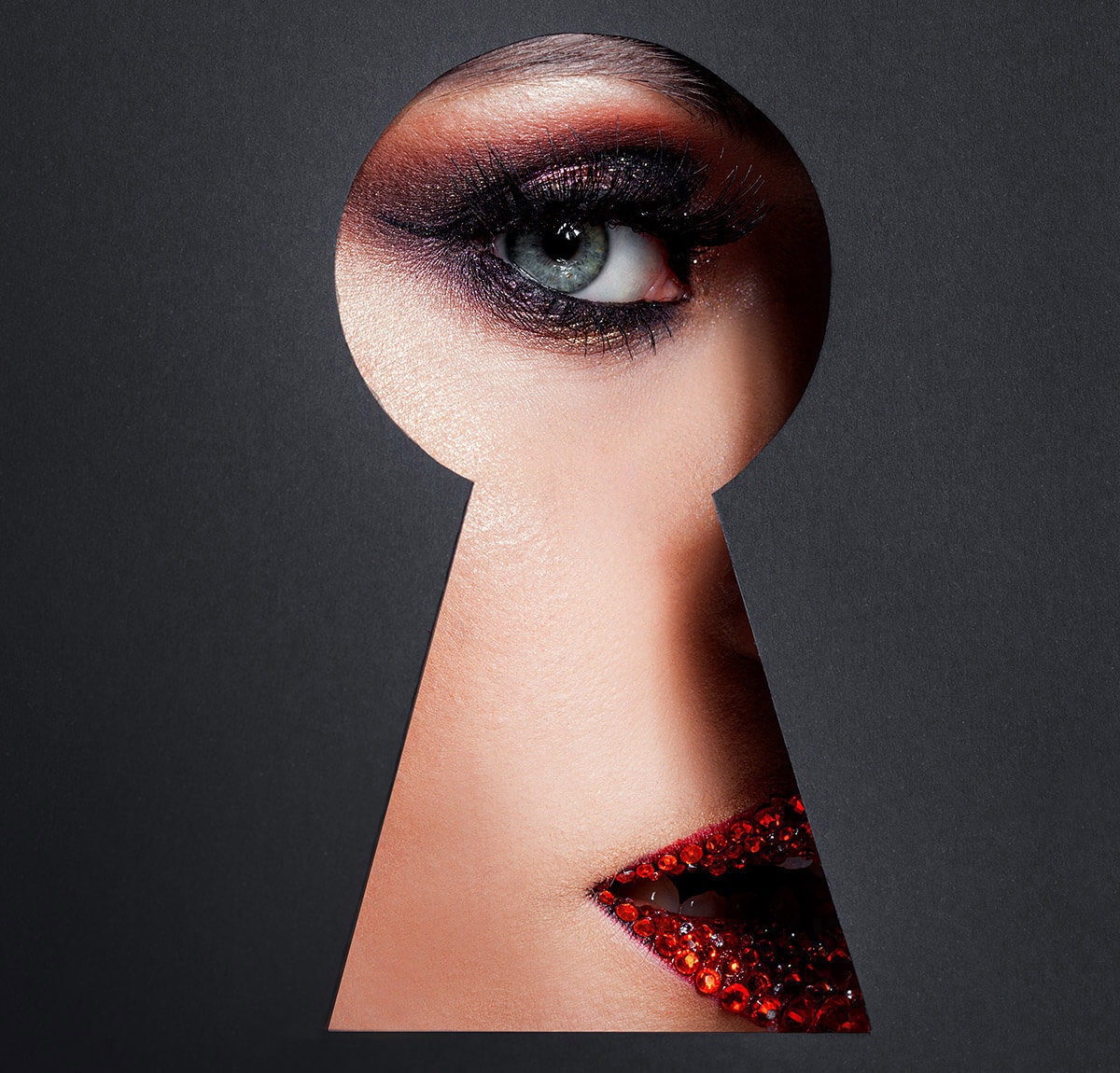 Image of a bright female eye looking through a keyhole Image of a bright female eye looking through a keyhole