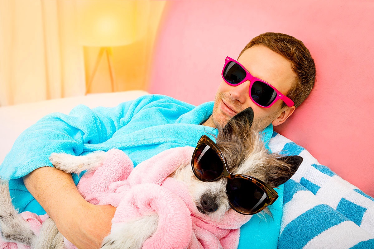Positive young guy with a dog in glasses