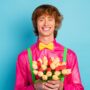 Image of a happy young man with a bouquet of flowers