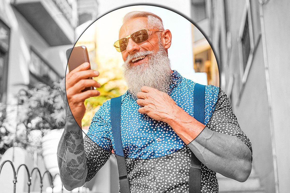 Elderly handsome man with a big beard and a mobile phone