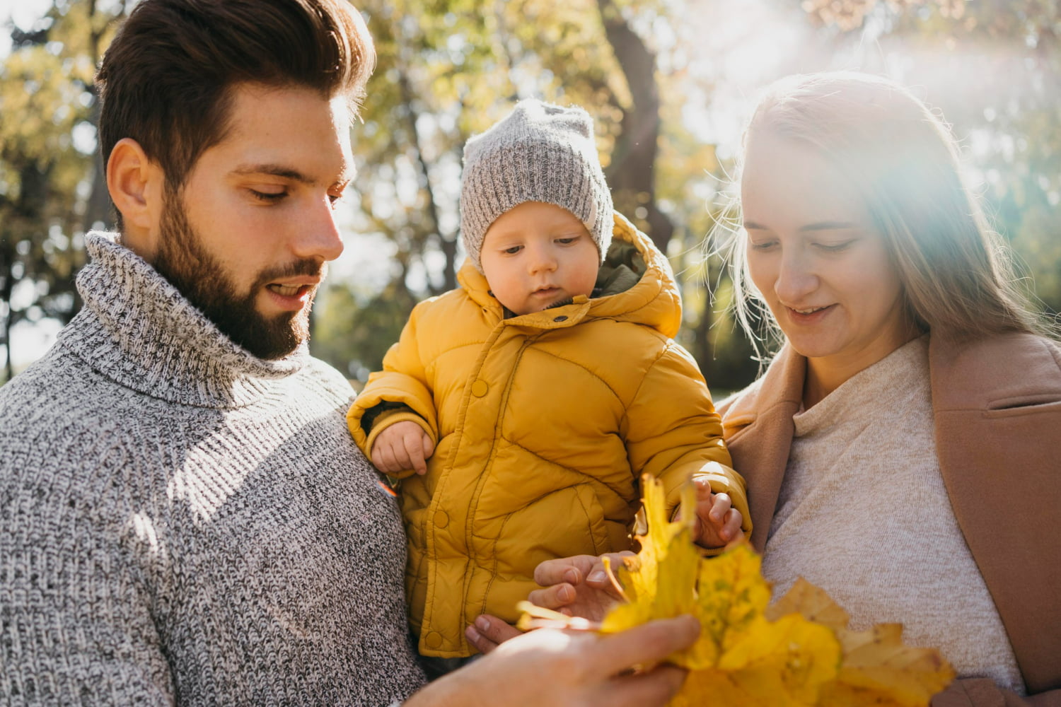 A young family spends time together outdoors on a sunny autumn day.