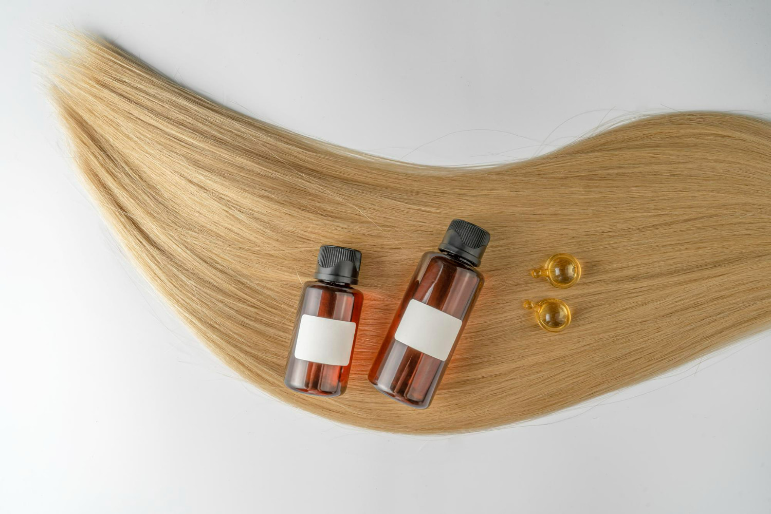 A luminous strand of flowing golden-blonde hair cascades gracefully across a pristine white background, creating an elegant canvas for this sophisticated product display.