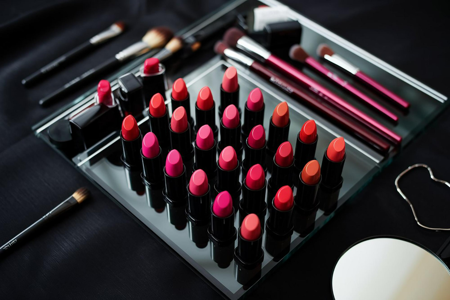 A stunning professional flat lay showcasing an extensive lipstick collection displayed in an elegant glass case.